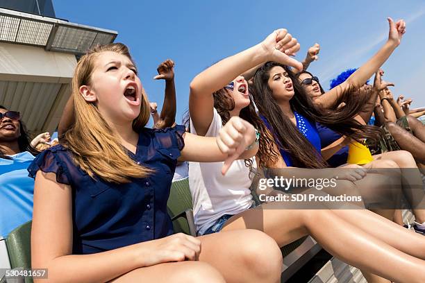 sports fans cheering and booing opposing team in stadium - family football team stock pictures, royalty-free photos & images