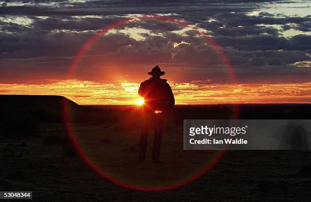 Tourist watches the sun rise on the Birdsville Track during the 2005 Great Australian Outback Cattle Drive June 10, 2005 near Marree, Australia....