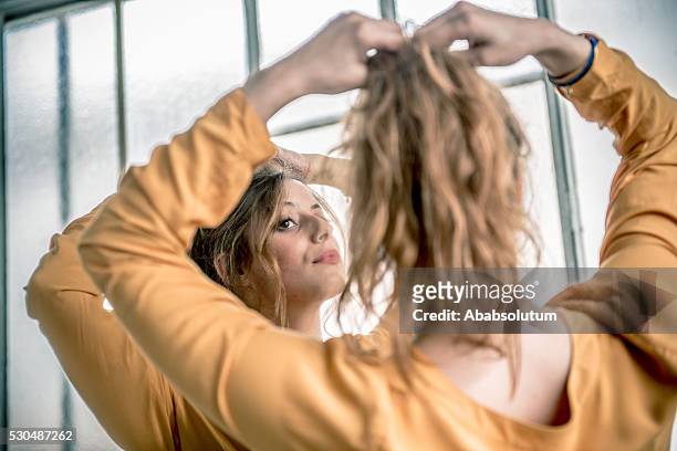 redhead woman looking at herself in mirror, paris, france - chignon stock pictures, royalty-free photos & images