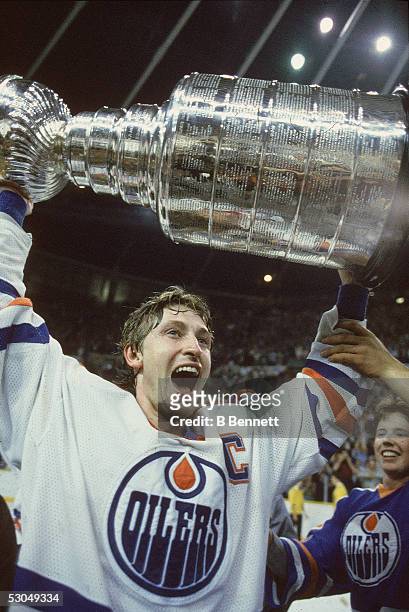 Wayne Gretzky of the Edmonton Oilers holds the Stanley Cup after the defeating the New York Islanders during the 1984 Stanley Cup Finals on May 19,...
