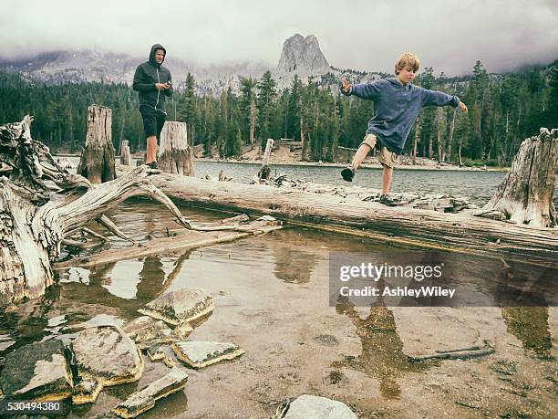 criança equilibrando-se sobre um água em um verão fresco lago de montanha - images of mammoth - fotografias e filmes do acervo