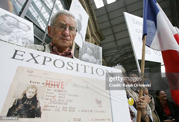 Henry Zajdenwerger, a deportation victim during World War II, displays a huge Identification card of a deported Jewish girl during a demonstration at...