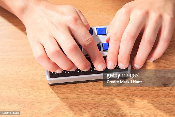 student with visual impairment using her braille display to communicate - braille stock pictures, royalty-free photos & images
