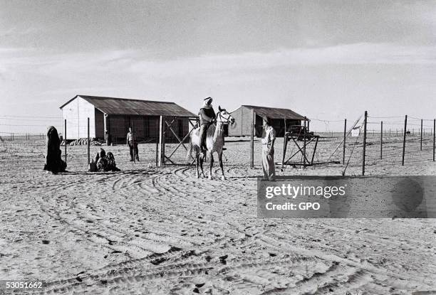 In this handout from the GPO, a Bedouin Arab family speaks with Jewish settlers at the gate of their cooperative farming community Septmber 30, 1946...