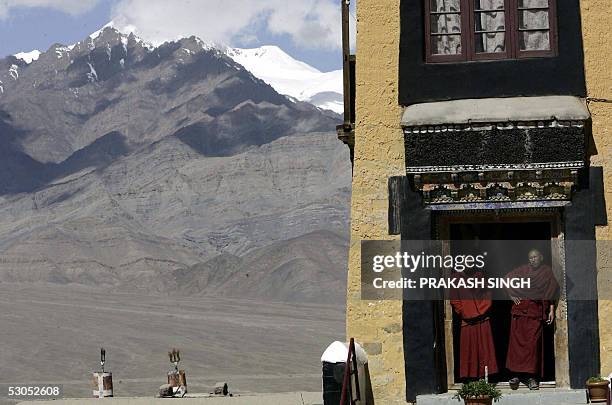 Ladakhi Buddhist monks stand in a doorway as they await the arrival of the wife of India's Prime Minister Gurcharan Kaur at Thiksey Monastery, some...