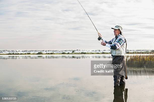 senior homme pêche à la mouche - freshwater fishing photos et images de collection
