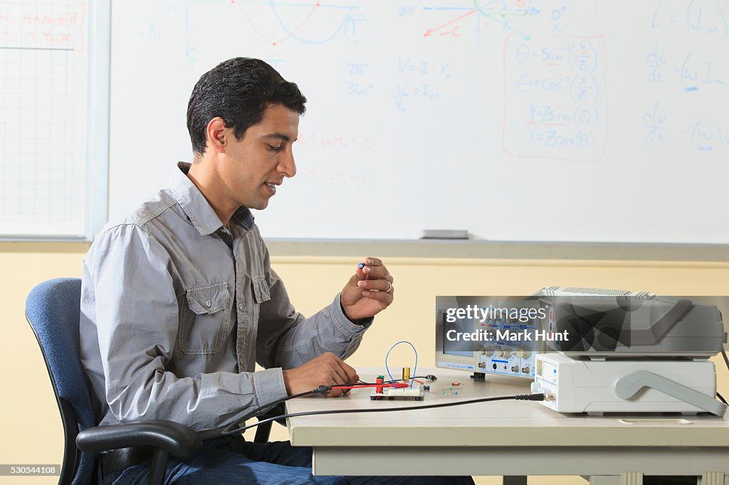 Engineering student preparing prototyping breadboard for an electronics lab experiment