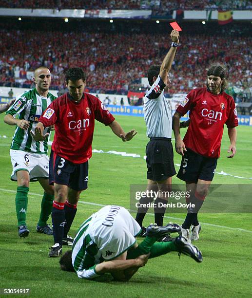 Referee Alfonso Perez gives Pablo Garcia of Osasuna the red card after he fouled Sanchez Joaquin of Real Betis in a Kings Cup final between Real...