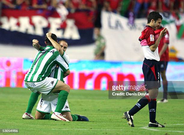 Teammates Fernando Varela and Daniel Martin Alexandre "Dani" #6 of Real Betis celebrate beside a crying Osasuna player after Betis beat Osasuna 2-1...