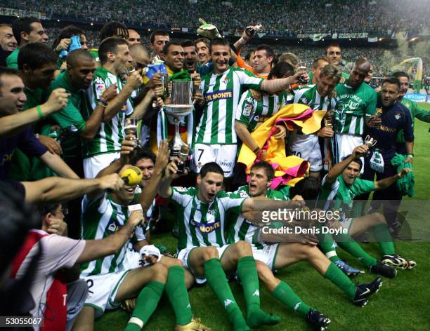 Real Betis players gather to celebrate with the trophy after beating Osasuna in a Kings Cup final on June 11, 2005 at the Calderon Stadium in Madrid,...