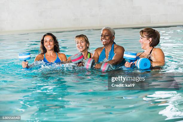 multiracial group of women in water aerobics class - aqua aerobics stockfoto's en -beelden