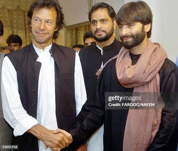 Pakistani cricketer-turned-politician Imran Khan shakes hands with the visiting Indian head of the pro-independence Jammu and Kashmir Liberation...