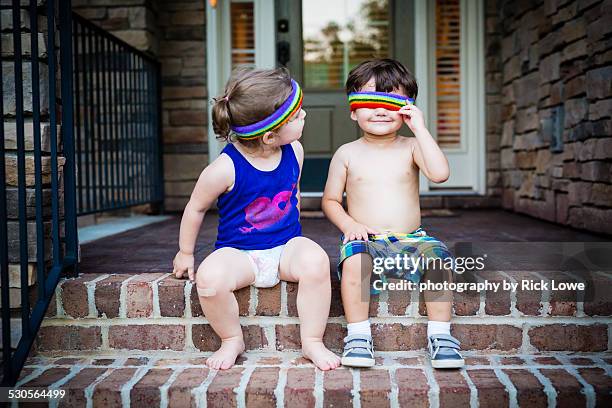Brother & sister playing on front steps of house