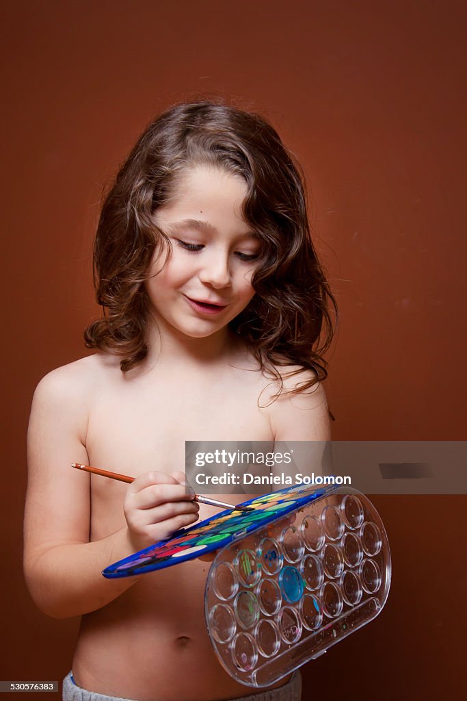 Boy with paintbrush and paints