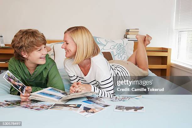 mother and son looking at pictures - bedroom photos stock-fotos und bilder