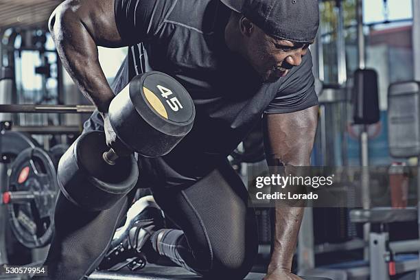 black male lifting dumbbells at a gym - athlete torso stock pictures, royalty-free photos & images