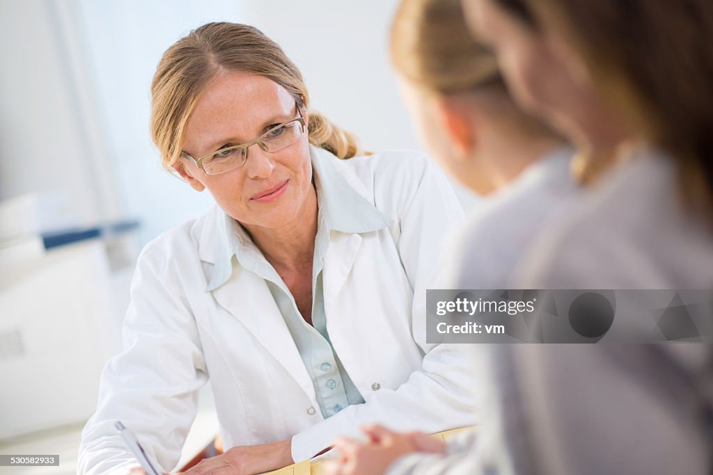 Weibliche Kinderarzt mit kleinen Patienten reden