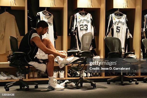 Tim Duncan of the San Antonio Spurs ties his shoes in the locker room prior to Game Two of the 2005 NBA Finals against the Detroit Pistons on June...