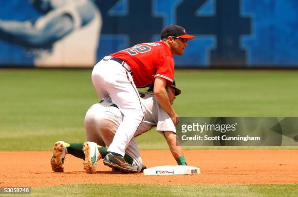 Second baseman Marcus Giles of the Atlanta Braves turns a double play despite the slide by Nick Swisher of the Oakland Athletics at Turner Field on...