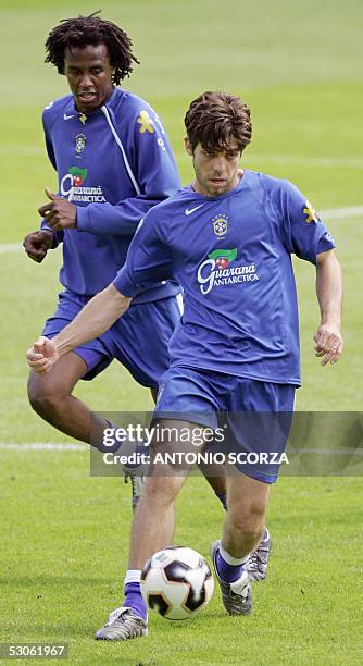 Brazil's national football team player Juninho Pernambucano kicks the ball 13 June 2005 as his teammate Roque Junior looks on during the afternoon...
