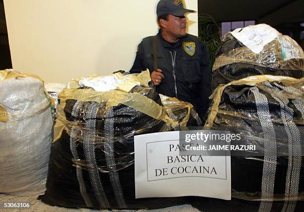 Un policia monta guardia junto a un cargamento de poco mas de una tonelada de cocaina y pasta basica de cocaina el 13 de junio de 2005 en Lima. La...