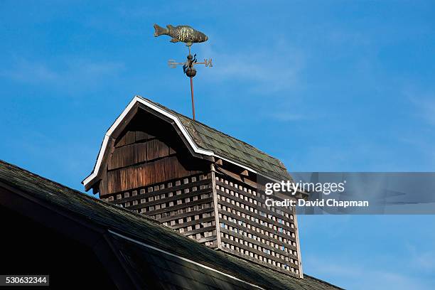 weather vane on an old barn roof; north hatley, quebec, canada - north hatley stock pictures, royalty-free photos & images