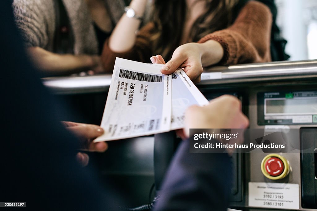 Travellers Getting Boarding Passes At Check-In