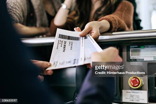 travellers getting boarding passes at check-in - aeroplane ticket stock pictures, royalty-free photos & images