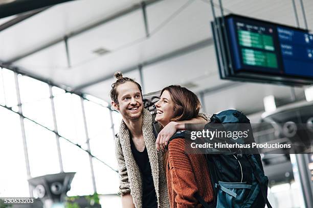 young backpacker couple at the airport - tourist couple fotografías e imágenes de stock