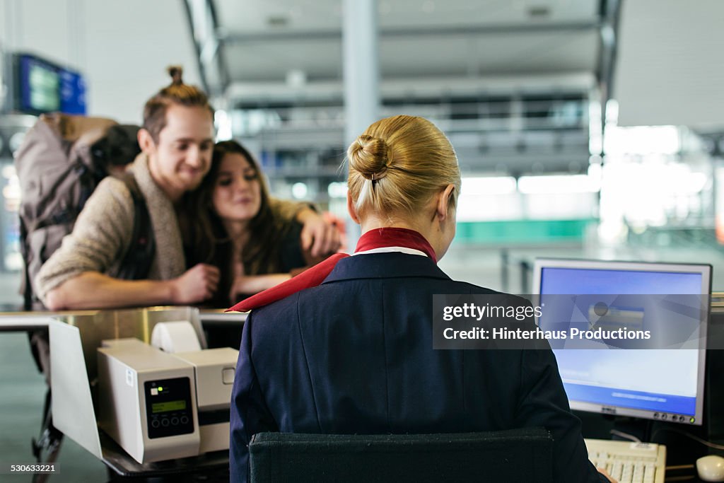 Backpacker Couple At Airline Check-in Counter