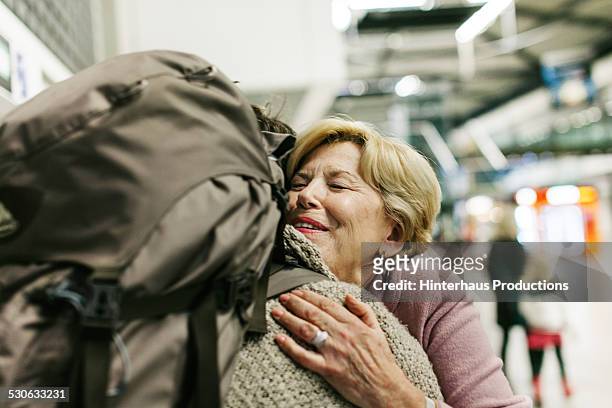 grandmother welcoming young traveller - arrival hug stock pictures, royalty-free photos & images