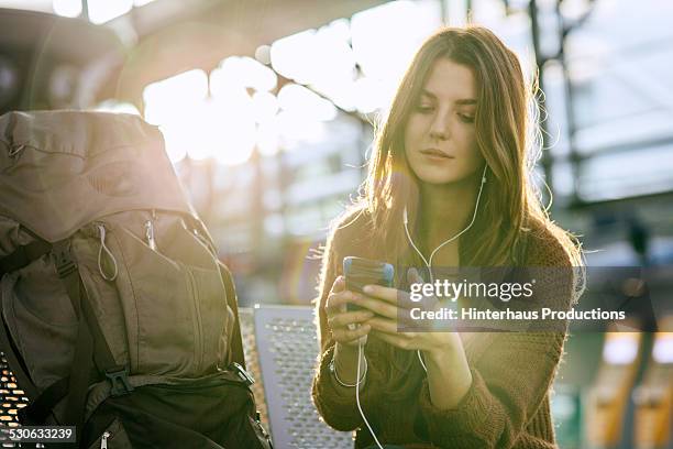 young backpacker with smart phone at airport - rugzaktoerist stockfoto's en -beelden