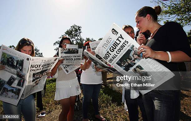 Michael Jackson fans read copies of a special edition of the Santa Maria Times newspaper outside Jackson's Neverland Ranch June 13, 2005 in Los...