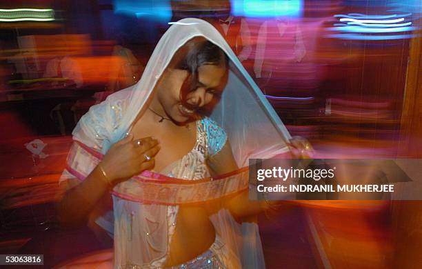 In this picture taken late 06 May 2005, An Indian bar dancer dances with a garland of currency notes offered by a customer during a performance at a...