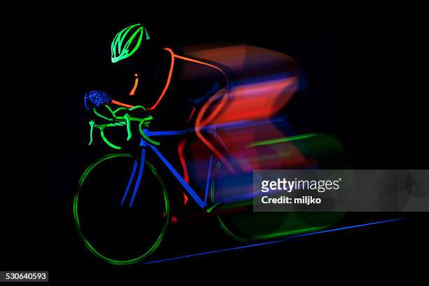 bicyclist ride bike colored with fluorescent color - strip lights stock pictures, royalty-free photos & images