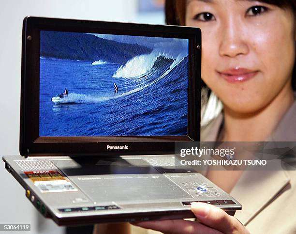 Japanese electronics giant Matsushita Electric Industrial employee displays the new portable DVD player "DVD-LX95", equipped with a 9-inch wide LCD...
