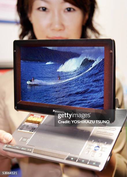 Japanese electronics giant Matsushita Electric Industrial employee displays the new portable DVD player "DVD-LX95", equipped with a 9-inch wide LCD...