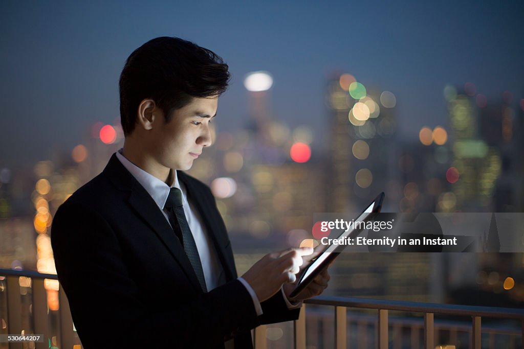 Businessman working on tablet at night