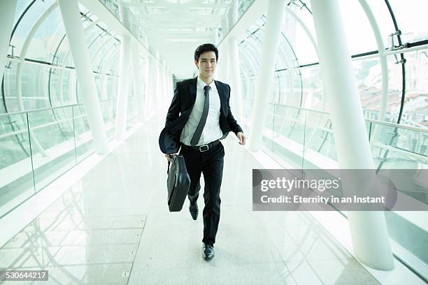 businessman running through glass tunnel - businessman running stock pictures, royalty-free photos & images