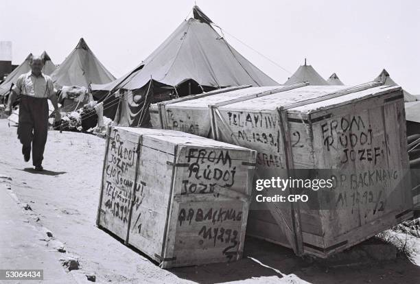 Recently-arrived Jewish man passes tent housing and packing crates at the new immigrants' camp December 1, 1949 at Beit Lid in the newly-established...