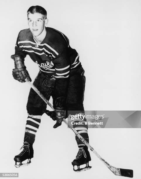 Silhouetted portrait of Canadian professional ice hockey player defenseman Bobby Orr as he poses at the ready with skates, stick, and gloves in the...