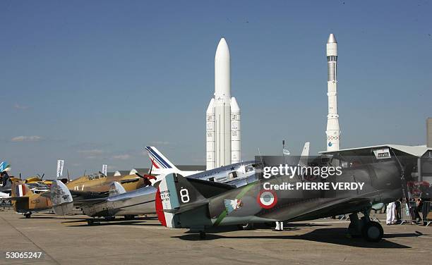 Old war planes are presented at Le Bourget Airport 13 June 2005. In the background two models of Ariane 1 and 5 part the Air Museum's collections....