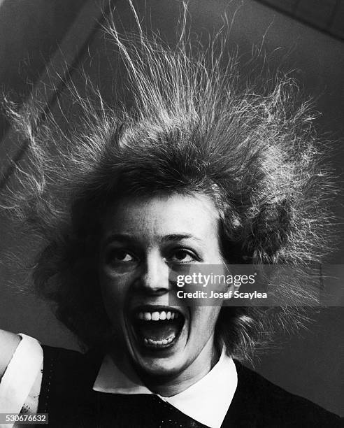 Student's hair goes frizzy and stands straight up during a static electricity experiment at the University of Washington. 1955.