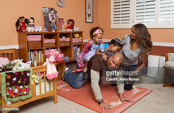 Coby and his wife Aviss play in the children's room with twin daughters Serrae and Jaena.
