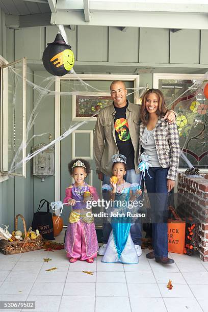 Twin daughters Serrae and Jaena pose in Halloween costumes with Coby and his wife Aviss.