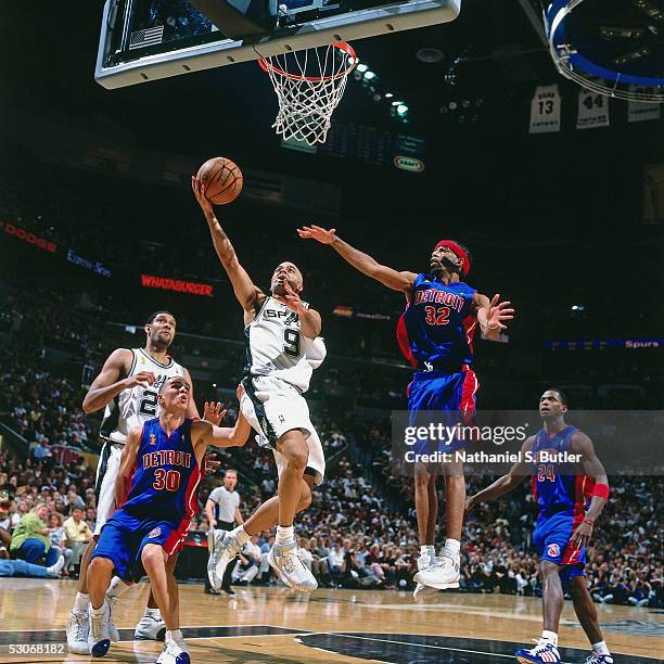 Tony Parker of the San Antonio Spurs shoots against Richard Hamilton and Carlos Arroyo of the Detroit Pistons in Game one of the 2005 NBA Finals at...