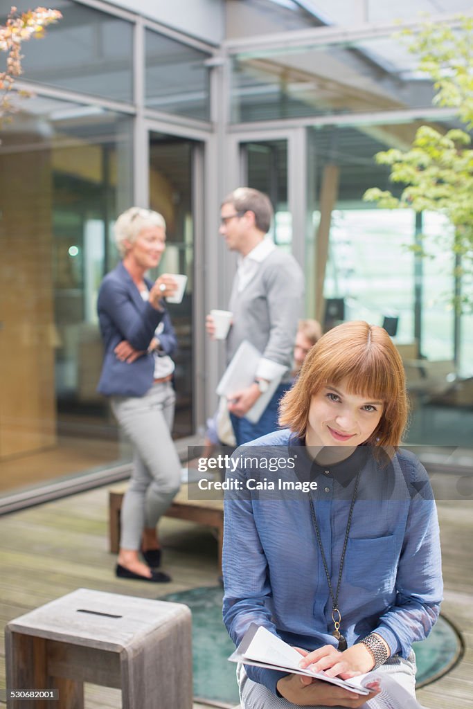 Businesswoman smiling in courtyard