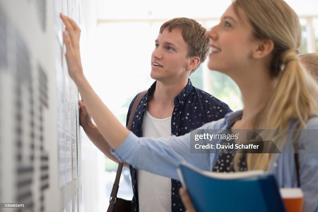 University students looking at test results in corridor