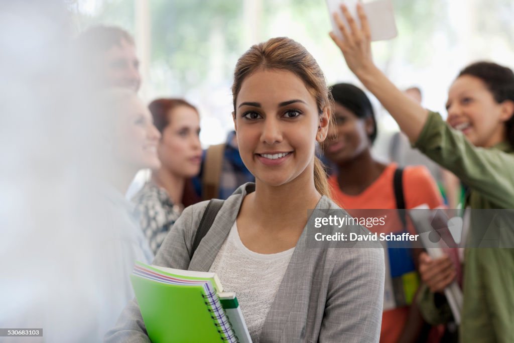 Studentessa sorridente che tiene libri durante la pausa