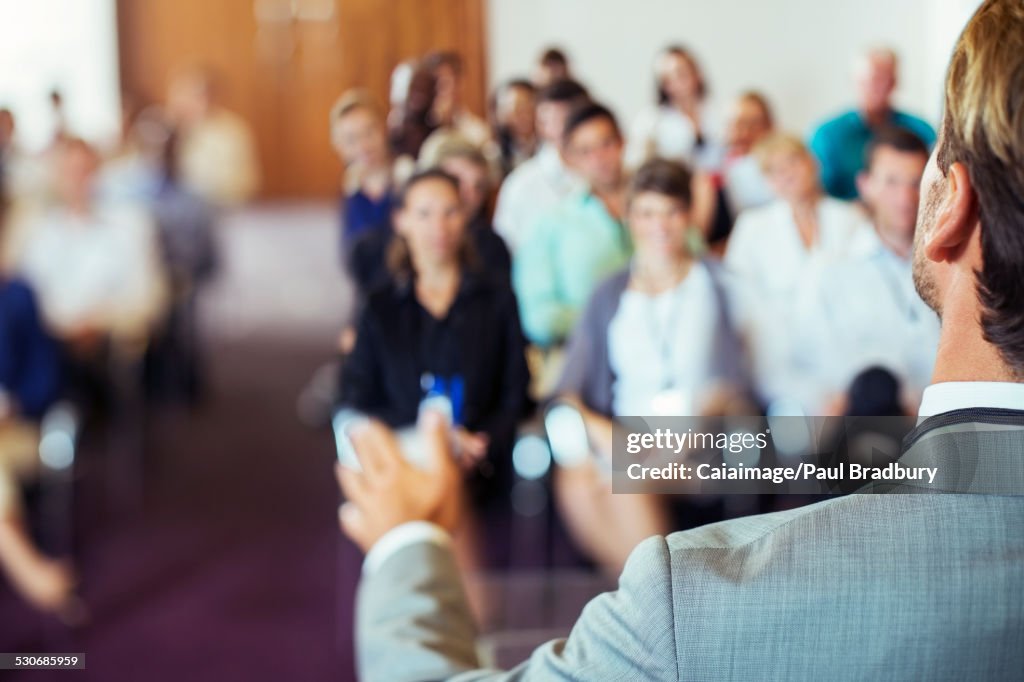 Businessman speaking to audience in conference room